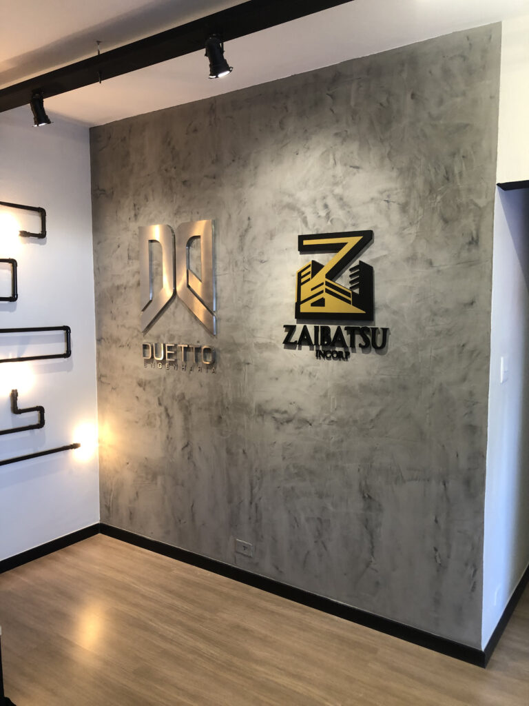 Letra-caixa em aço escovado.