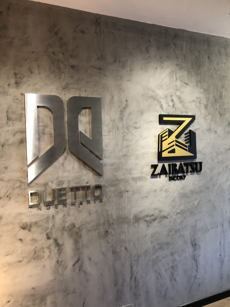 Letra-caixa em aço escovado.