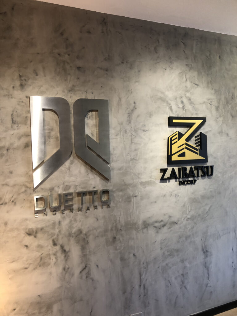 Letra-caixa em aço escovado.