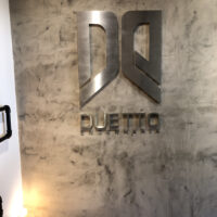 Letra-caixa em aço escovado.